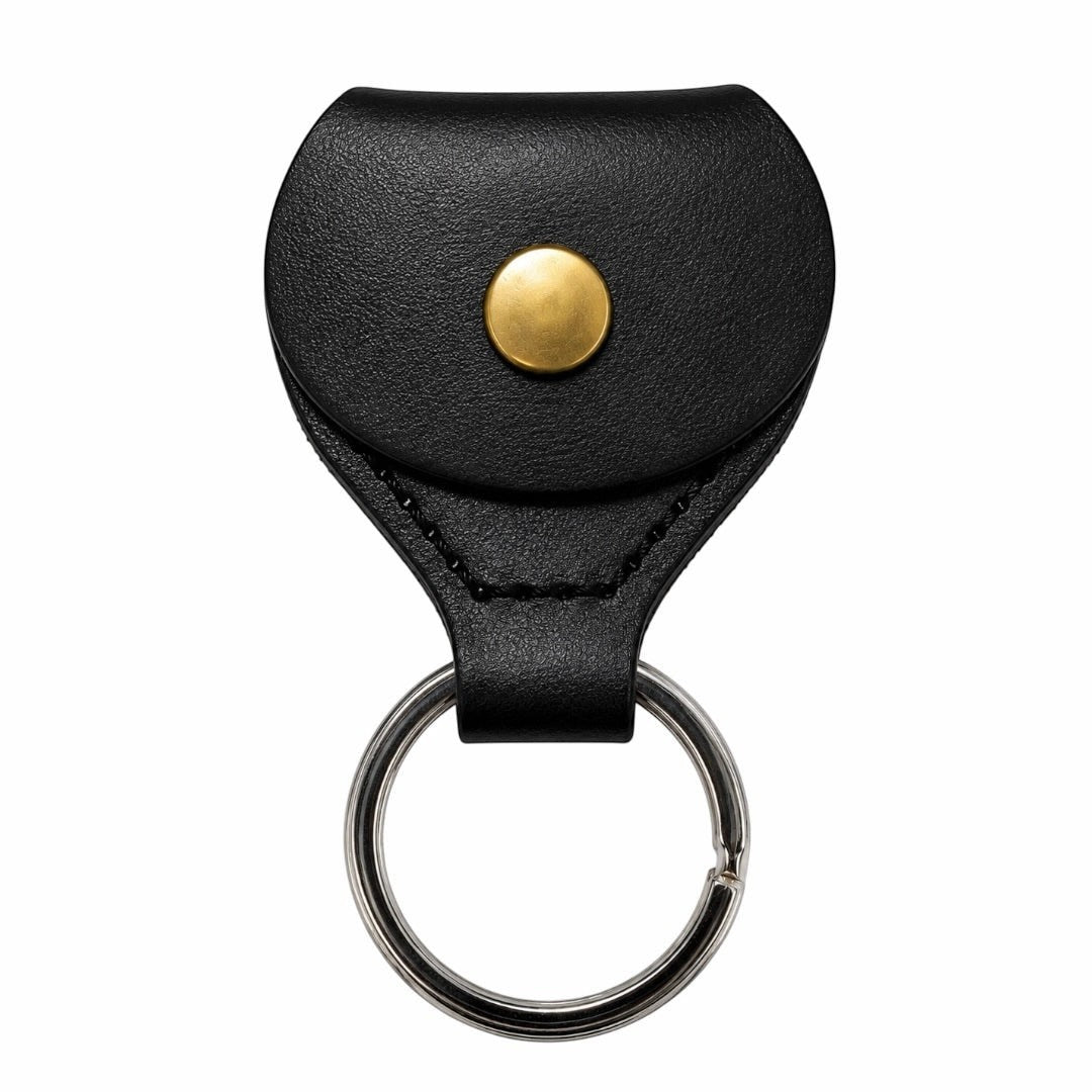 Prathmesh Music black leather guitar pick holder keychain with a gold snap button closure.