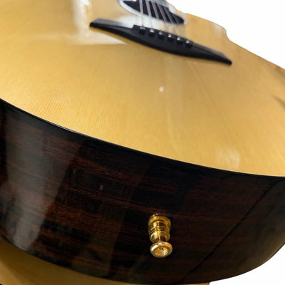 Prathmesh Music gold HT guitar strap lock installed on the side of an acoustic guitar body