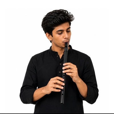 A young man playing a black Prathmesh Music Radhe straight PVC fiber flute, designed for beginners and students.